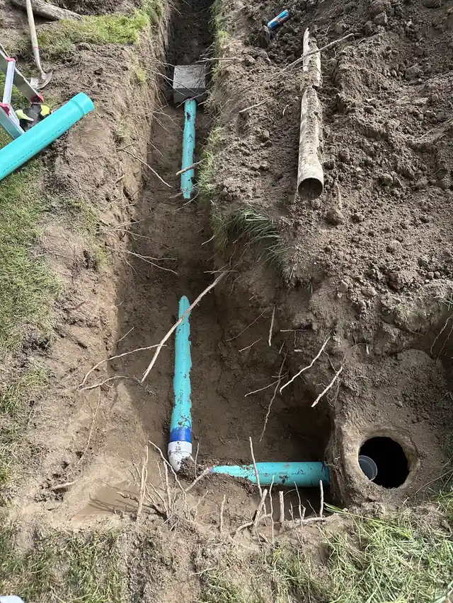 New green PVC sewer pipe laid in a trench beside the old pipe that CSR pulled out